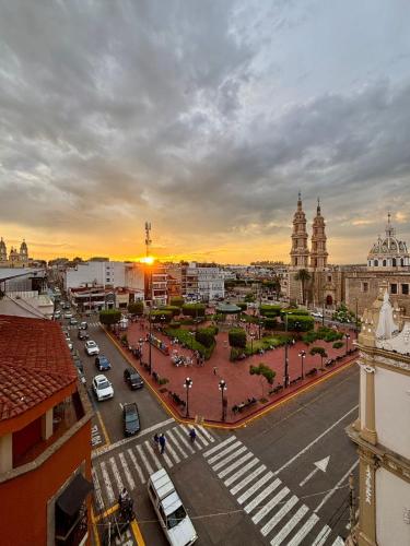 a city street with a sunset in the background at Hotel Plaza in Tepatitlán de Morelos