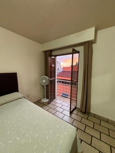 a bedroom with a bed and a view of a balcony at Hotel Plaza in Tepatitlán de Morelos