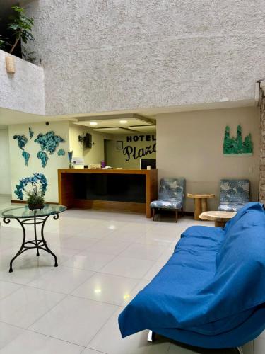 a bedroom with a blue bed and a tv at Hotel Plaza in Tepatitlán de Morelos