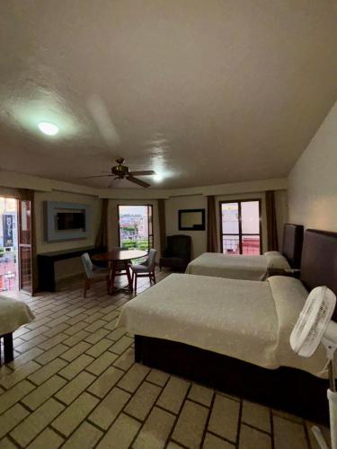 a bedroom with two beds and a table and chairs at Hotel Plaza in Tepatitlán de Morelos