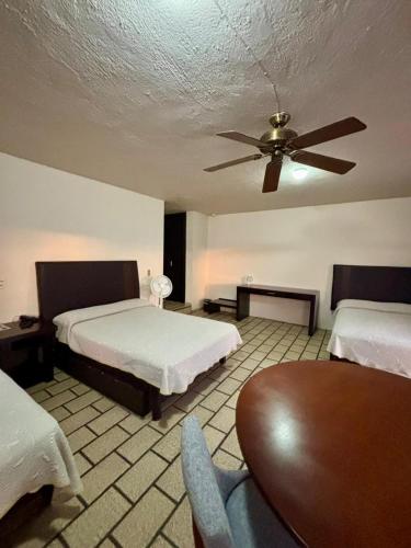 a bedroom with two beds and a ceiling fan at Hotel Plaza in Tepatitlán de Morelos