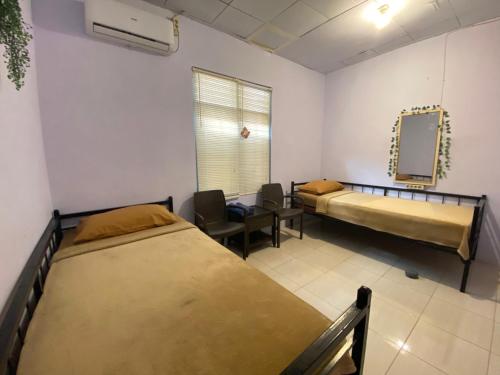 a hospital room with two beds and a mirror at Neo Robiu & Ijen Tour in Banyuwangi