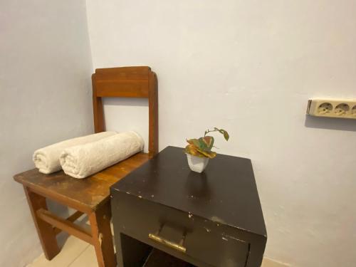 a black desk with a plant on it next to a chair at Neo Robiu & Ijen Tour in Banyuwangi