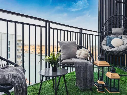 a balcony with chairs and tables and a view of a city at DVH Luxe Retreats 1BR Yas Island by Ferrari World and Yas Mall in Yas Island