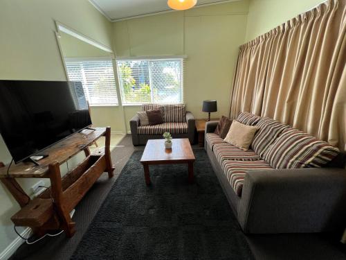 a living room with a couch and a flat screen tv at Coconut Palms in Scarness