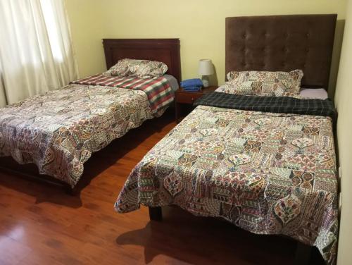 a bedroom with two beds and a table with a lamp at Apartamento familiar in Cuenca