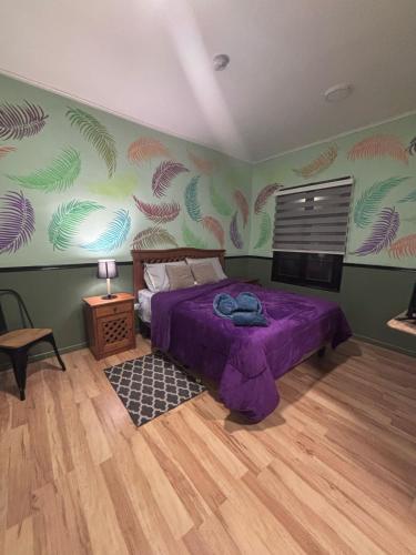 a bedroom with a purple bed and green walls at Hotel Minga in Copiapó