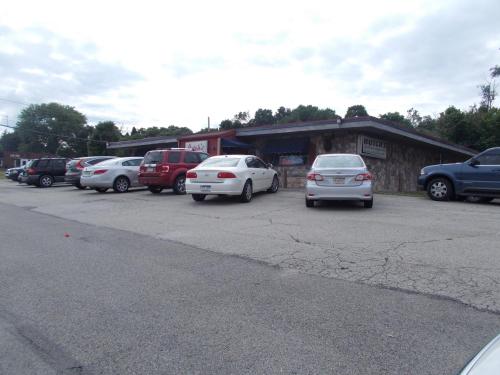 a parking lot with cars parked in front of a building at Melody Motor Lodge in Connellsville