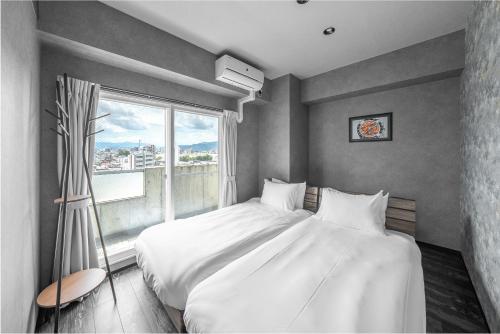 a bedroom with a large white bed and a window at J-star 901 in Sapporo