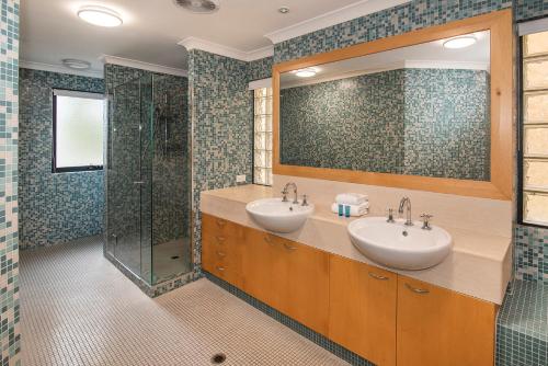 a bathroom with two sinks and a shower at Sebels Beach front Bungalow in Broadwater