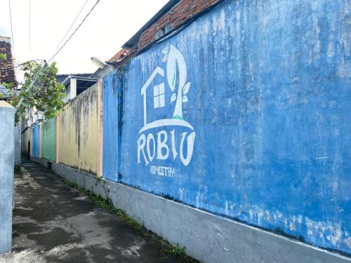 a blue wall with a raboco painted on it at Neo Robiu & Ijen Tour in Banyuwangi