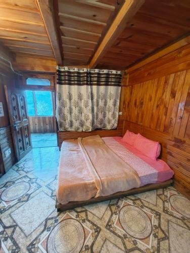 a bedroom with a bed in a room with wooden walls at Oran Stays Shoja in Shoja