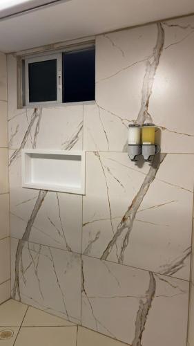a bathroom with a white marble wall with a window at Blue Sunset Experience in João Pessoa