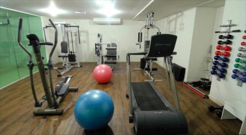 a gym with exercise equipment and a blue ball on the floor at Blue Sunset Experience in João Pessoa
