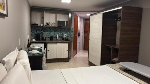 a room with a bed and a kitchen in it at Blue Sunset Experience in João Pessoa
