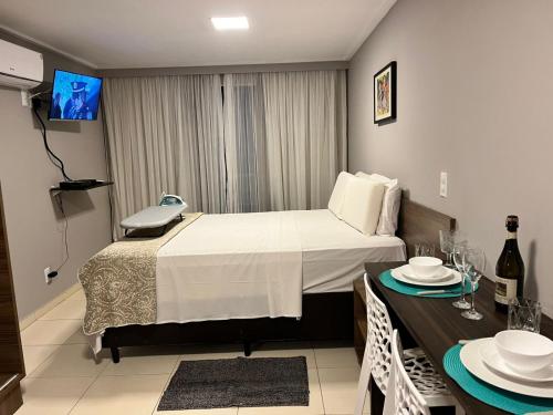 a hotel room with a bed and a table with plates on it at Blue Sunset Experience in João Pessoa