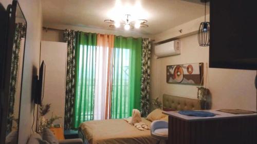 a bedroom with a bed and a green curtain at Studio w pool & balcony, city & mountain view Mactan airport in Suba