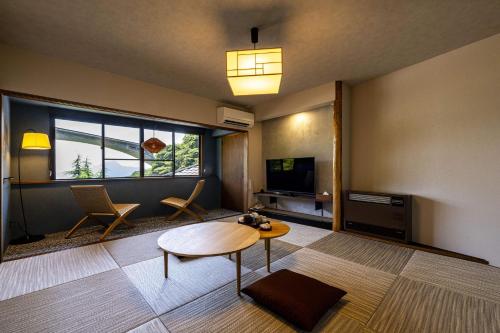 a living room with a table and a tv at Okamotoya in Beppu