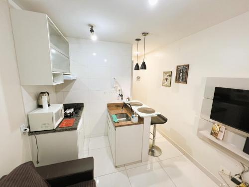 una cucina bianca con un lavello e un forno a microonde di Hospede-se com conforto no Setor Sudoeste a Brasilia