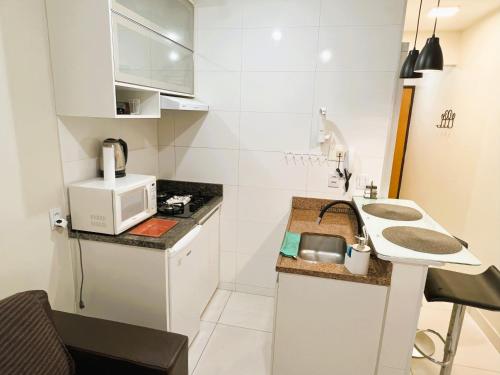 una piccola cucina con lavello e microonde di Hospede-se com conforto no Setor Sudoeste a Brasilia