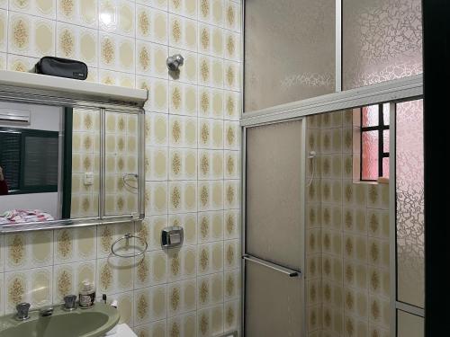 a bathroom with a sink and a mirror and a shower at Suite em casa familiar in São Gabriel
