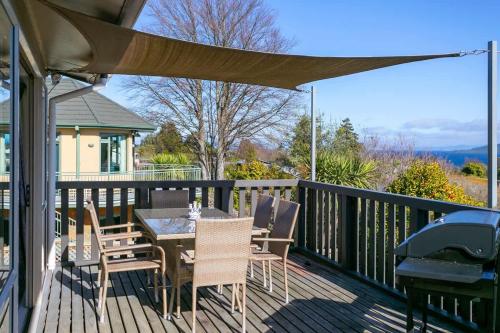 a patio with a table and chairs on a deck at Mercy of Lake Taupo in Taupo