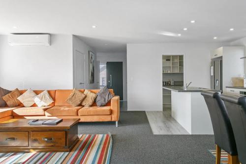 a living room with a couch and a table at Huka Falls Getaway (Family escape) in Taupo