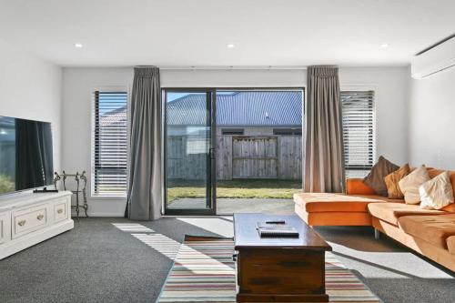 a living room with a couch and a tv at Huka Falls Getaway (Family escape) in Taupo