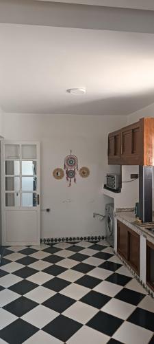 a kitchen with a black and white checkered floor at Maison spacieuse avec jardin et parking in Sale