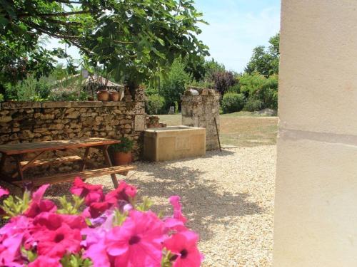 a park with a bench and some pink flowers at Maison familiale avec grand jardin près du Périgord - 3 chambres, WIFI et vélos fournis - FR-1-653-171 in Combiers