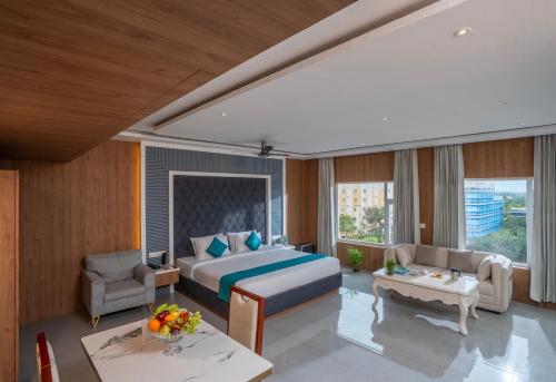 Un dormitorio con una cama, un sofá y una mesa. en Hotel SS Palace, en Rameswaram