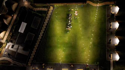 an overhead view of a large green field at night at Bukit Langit Campventure in Glagah