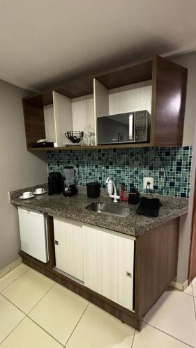 a kitchen counter with a sink and a microwave at Blue Sunset Experience in João Pessoa