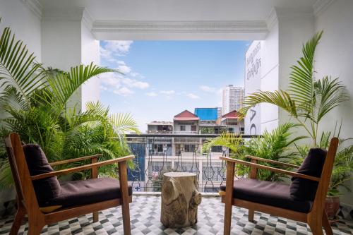 a balcony with two chairs and some plants at Pacific Hotel in Phnom Penh