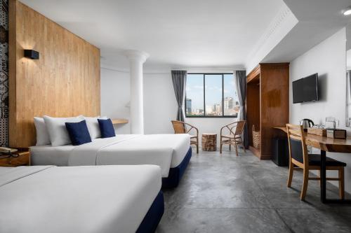 a hotel room with two beds and a table at Pacific Hotel in Phnom Penh