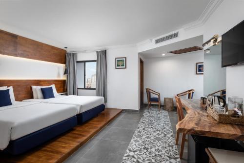 a hotel room with a bed and a desk at Pacific Hotel in Phnom Penh