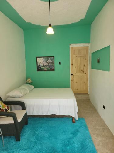 a bedroom with a bed and a chair and a door at Cozy 1 Bedroom studio apartment with private parking near Yallahs in St Thomas Jamaica 