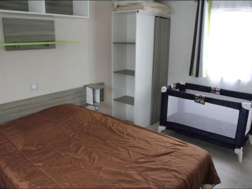 a bedroom with a bed and a book shelf at Mobil home confortable avec terrasse à Bretignolles-sur-Mer - API-1-52-656 in Brétignolles-sur-Mer