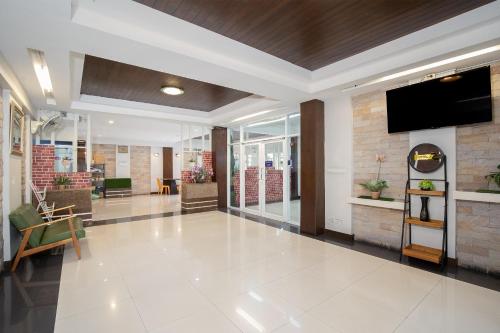 an office lobby with a flat screen tv on the wall at P-Park Suvarnabhumi in Bangkok