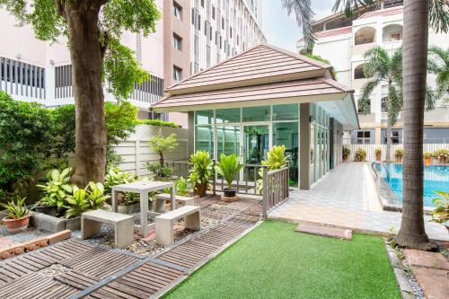 a garden with a pool and a building at P-Park Suvarnabhumi in Bangkok