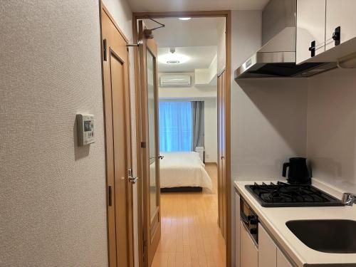 a small kitchen with a sink and a stove at Sunshine Grand Hotel Ikebukuro in Tokyo
