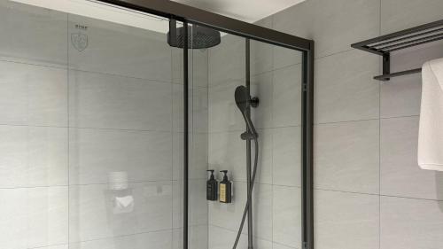 a shower with a glass door in a bathroom at Talmud Hotel Classic Taiwan Boulevard in Taichung
