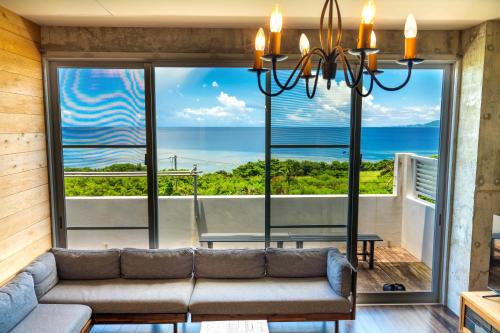 a living room with a couch and a large window at "NICE!" Ocean view of Ishigaki island, Okinawa/ Four-bedroom Villa in Ishigaki Island