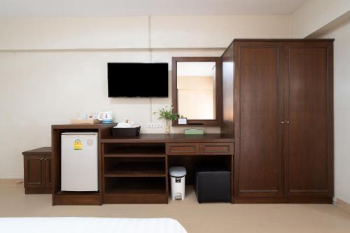 a room with a desk with a television and a refrigerator at P-Park Suvarnabhumi in Bangkok