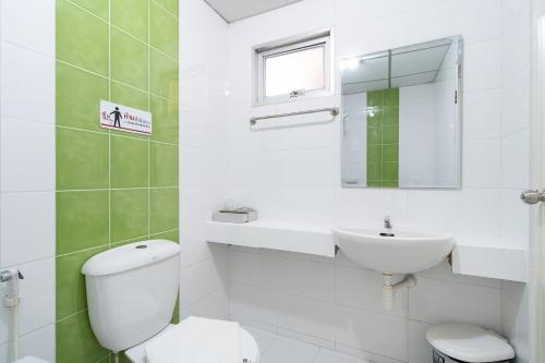 a white bathroom with a toilet and a sink at P-Park Suvarnabhumi in Bangkok