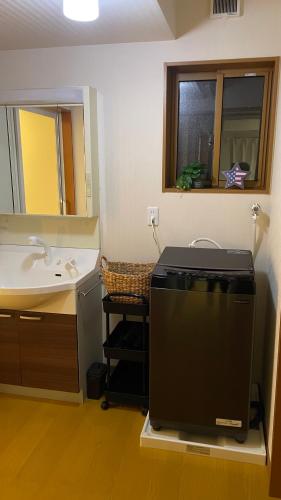 a bathroom with a sink and a flat screen tv at POLARiS in Tateyama