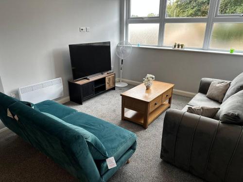 a living room with a couch and a tv at Melbourne House Apartment Near Train Station! in Accrington