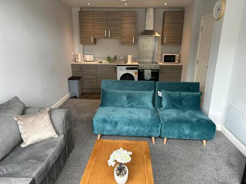 a living room with a couch and a table at Melbourne House Apartment Near Train Station! in Accrington