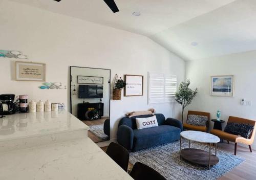 ein Wohnzimmer mit einem blauen Sofa und einem Tisch in der Unterkunft #Marbella Lane - Stylish Haven Near City Center in Long Beach