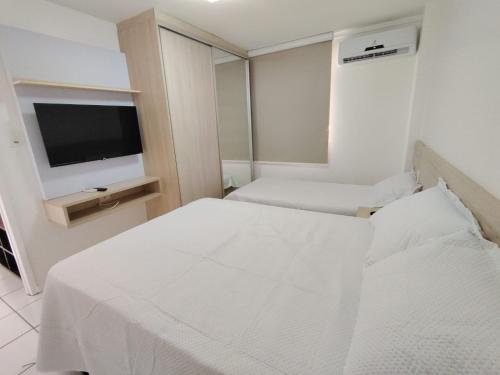 a hotel room with two beds and a flat screen tv at Resort Grand solare residence in Barreirinhas